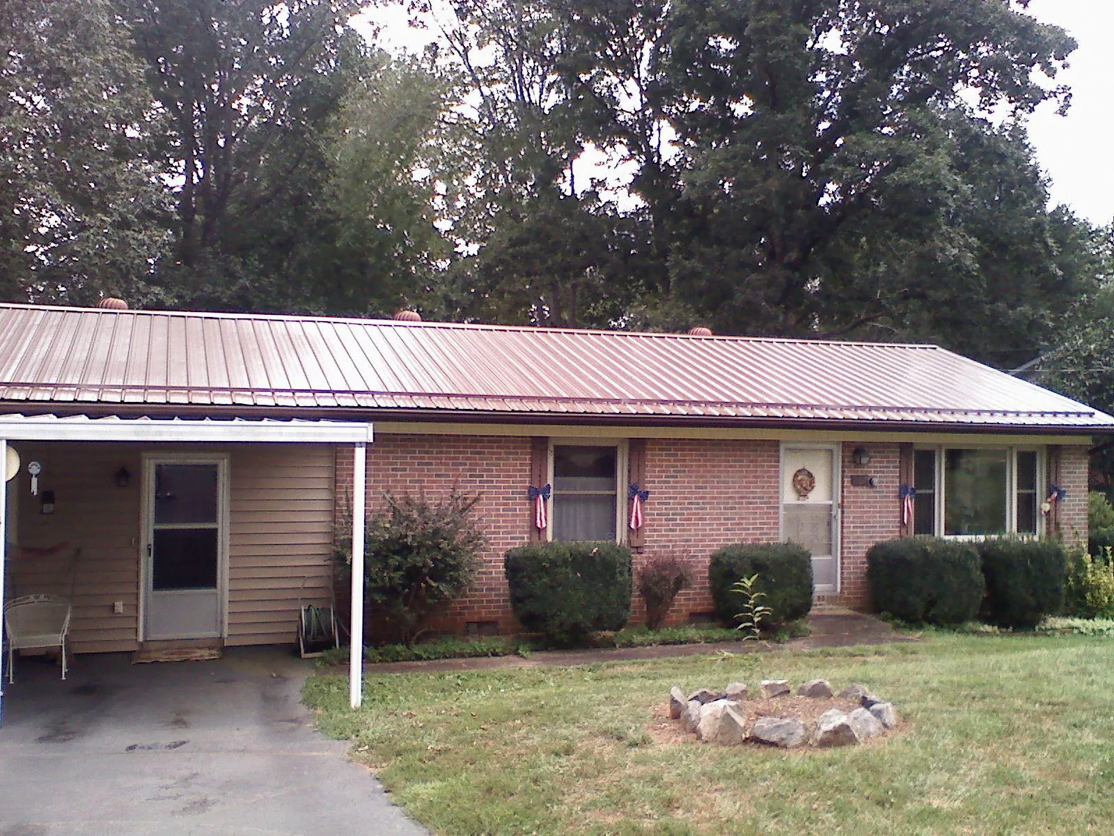 Bronze metal roof and carport on a brick ranch home — Roof Repair work by our crew in Diamond