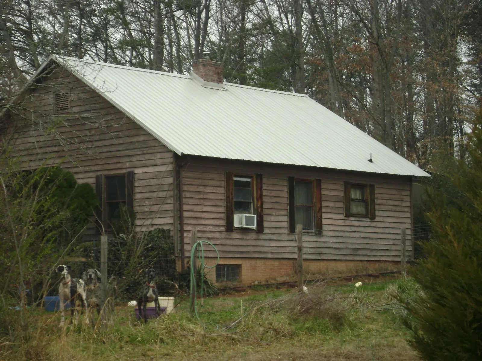 White metal roof on an old wood sided farmhouse, from a Metal Roof Installation job in Diamond